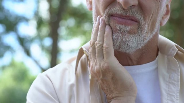 Senior man having problem with teeth, social program of dental prosthetics