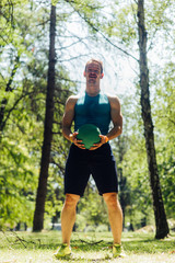 Handsoome man doing workout with medecine ball outdoors