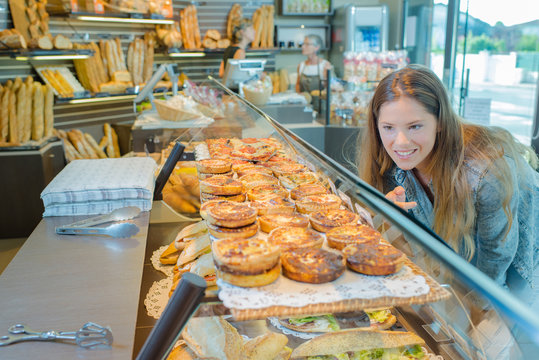 Lady In Bakery Looking In Counter