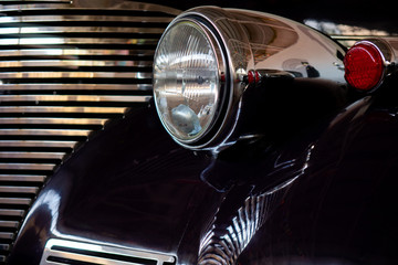 The headlight of an antique, rarity, vintage black car.