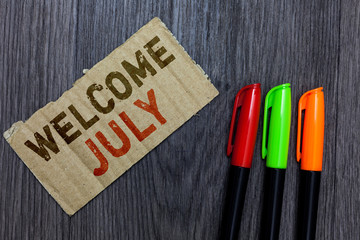 Word writing text Welcome July. Business concept for Calendar Seventh Month 31days Third Quarter New Season Paperboard Important reminder Communicate ideas Markers Wooden background