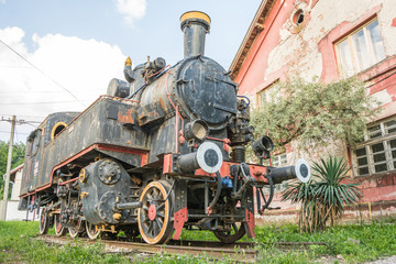 Fototapeta na wymiar Old Yugoslavian locomotive near old train station