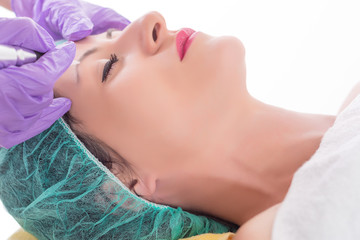 Micro pigmentation or permanent make up on eyebrow. Beautician applying tattoo with professional tool in beauty studio. Close up, selective focus