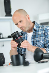 focused man fixing camera at his workplace