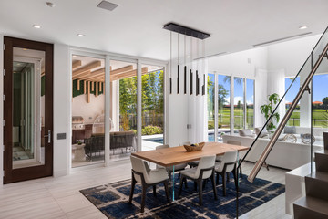 modern open plan white living room with wood details overlooking golf course