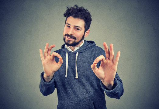 young handsome confident man showing ok sign