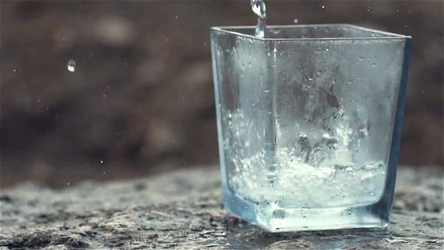 100fps Slow Motion of Sparkling Water and Lemon Falling into Glass