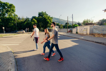 Group Of Friends Crossing The Street On Pedestrian Crossing. Young and careless friends concept.