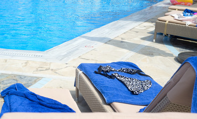 Fototapeta na wymiar Woman's swimming suit on a sun bed near the pool