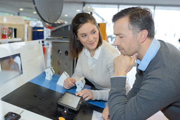 couple choosing kitchen stove in hypermarket and smiling