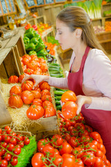 Shop worker carrying a crate of tomatoes