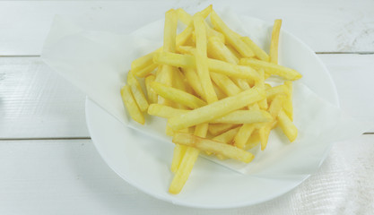French Fries in a white dish on a table white background, Front view, Close up, with copy space for your text..