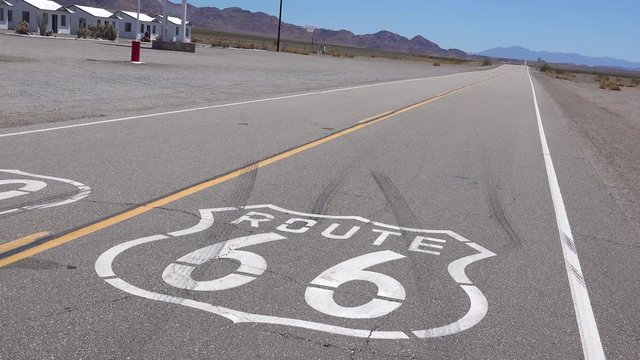 Establishing shot of a lonely desert highway in Arizona with Route 66 painted on the pavement.