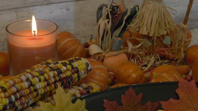 Candle burning on a table set with fall decorations