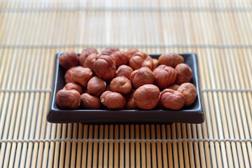 Hazelnut in a plate on a bamboo Mat