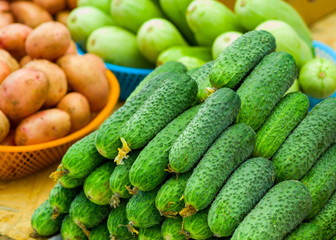 fresh cucumbers on the counter, potatoes and zucchini