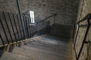 Inside metal stairwell with stone walls, no people, interior