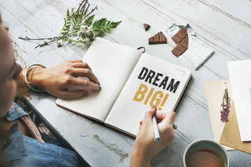 Woman writing Dream big on a notebook - obrazy, fototapety, plakaty