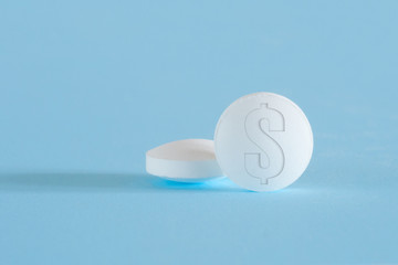 Two tablets with the dollar symbol on blue background. The concept of high cost of medicine.