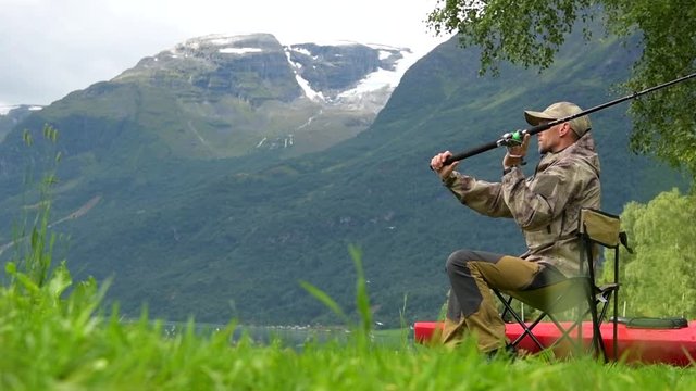 Caucasian Fisherman in His 30s Fly Fishing on the Glacial Lake Slow Motion Footage