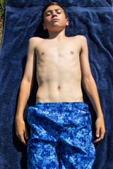 Teenage boy sunbathing in the garden © Ben Gingell