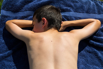 Teenage boy sunbathing in the garden