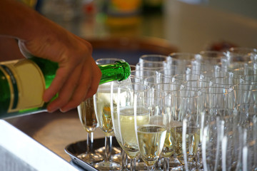 bottle of sparkling wine, poured in champagne cups