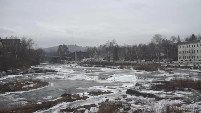 Partially frozen river running through ice and rocks in northeast