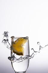 Glass of liquid with splash made dropping a slice of orange