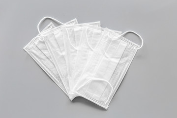 Flu prevention. Medical face masks on grey background top view copy space