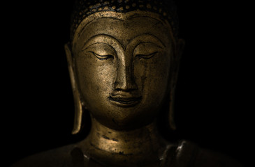 Smiling buddha against a black background