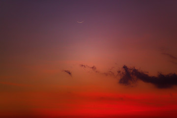 Young Moon photographed from southern hemisphere above the ocean / sea horizon.