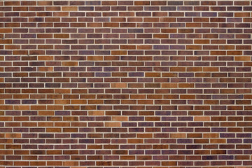 Traditional running bond pattern brown brick wall background in varying shades of brown, blue and red