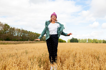 Outdoor atmospheric lifestyle photo of young beautiful  darkhaired woman  in knitting hat in sunny autumn day