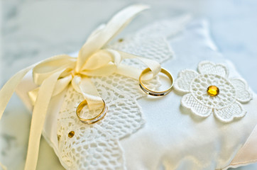 gold double rings on white pillow