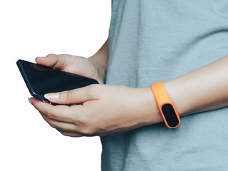 Woman with fitness tracker on her wrist is holding a phone.
