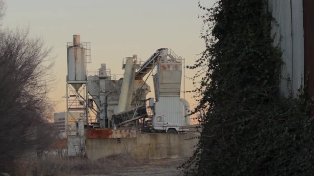 A dump truck lowering it's bed and driving away.