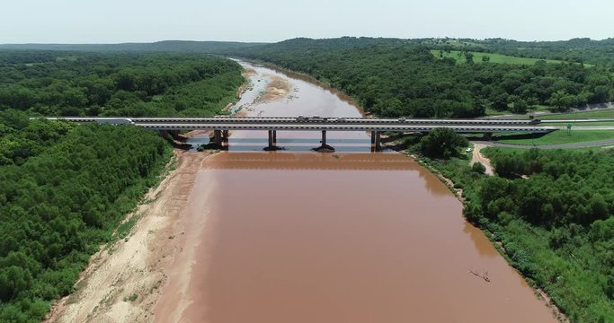 Aerial video of the Red River which borders between Texas and Oklahoma.  This was shot just west of where highway 35 crosses the river into Oklahoma.  Vehicles crossing the bridge between states.