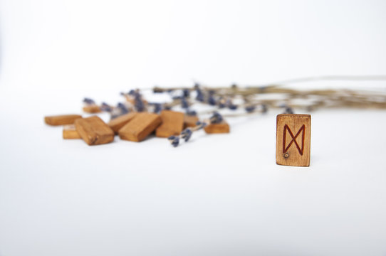 Dagaz. Scandinavian runes. Wooden runes on a table on a white background.