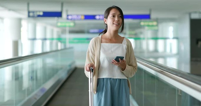 Woman walking with her luggage in airport