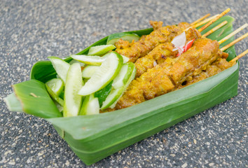 Thailand street food  barbecue pork with cucumber in banana leav