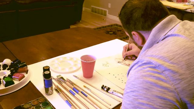 Artist painting an abstract portrait in watercolor - LOOKING OVER SHOULDER AND PANNING LEFT