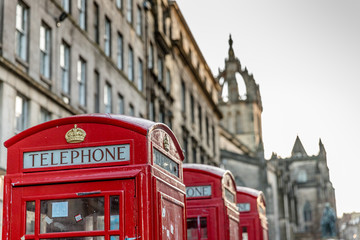 Fototapeta na wymiar Red phone booths across the famous Royal Mile in Edinburgh, Scotland