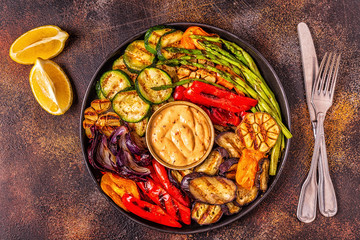 Grilled vegetables on a plate with sauce.