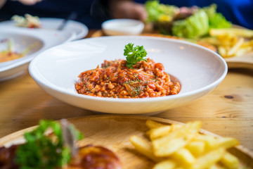 Spaghetti with minced pork tomato sauce on white dish in restaurant