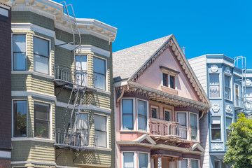 Fototapeta na wymiar San Francisco, typical colorful houses with fire escape staircases outdoors 