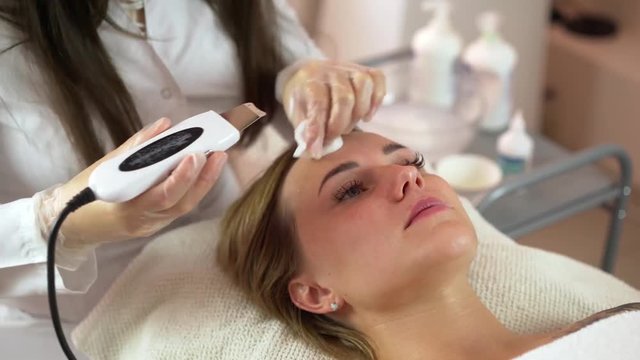 Woman getting rf lifting in her face in clinic. Anti-aging RF-therapy, rejuvenation and lifting procedure.