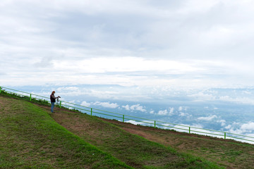 Nature photographer taking photos in the mountains with clouds