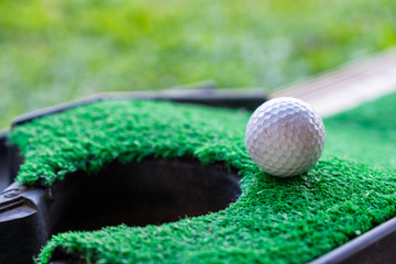 Golf ball edge hole cup on lawn