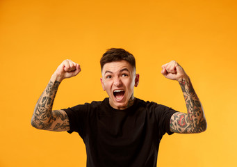 I won. Winning success happy man celebrating being a winner. Dynamic image of caucasian male model on gold studio background. Victory, delight concept. Human facial emotions concept. Trendy colors